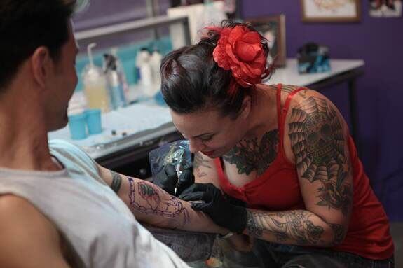 Tattoo artist, Jessica Rotwein creates art on a skin during the “Ink Challenge.”